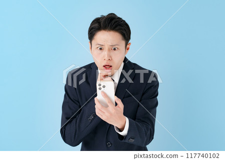 A businessman surprised with a smartphone 117740102