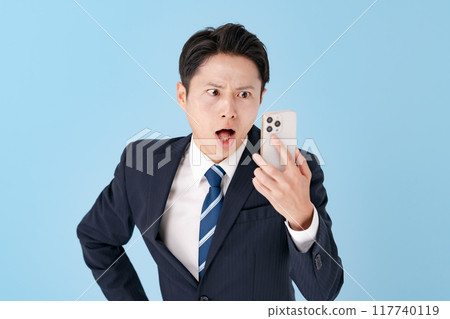 A businessman surprised with a smartphone A businessman surprised with a smartphone 117740119