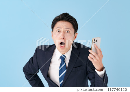 一位商人驚訝與智能手機 117740120