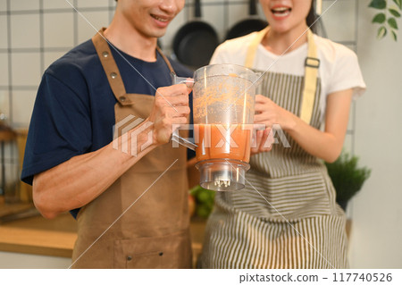 Cropped shot of healthy young couple holding a blender making smoothies in their kitchen at home Cropped shot of healthy young couple holding a blender making smoothies in their kitchen at home 117740526