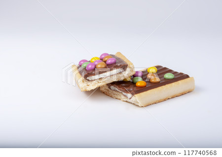 Chocolate bar snack with colorful drops or dragee isolated on the white Chocolate bar snack with colorful drops or dragee isolated on the white 117740568