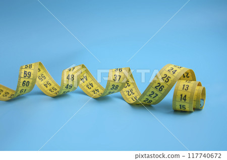 Yellow centimeter tape on blue background Yellow centimeter tape on blue background 117740672