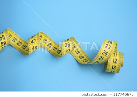 Yellow centimeter tape on blue background Yellow centimeter tape on blue background 117740673