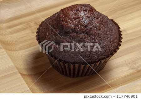Dark chocolate muffin on wooden dish Dark chocolate muffin on wooden dish 117740901