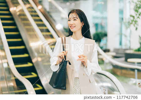 A woman riding an escalator A woman riding an escalator 117742706