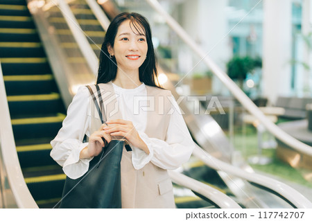 A woman riding an escalator A woman riding an escalator 117742707