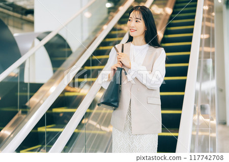 A woman riding an escalator 117742708