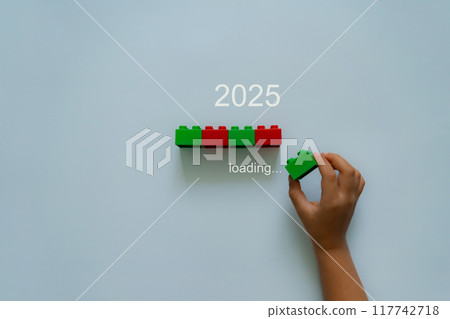 Loading new year 2024 to 2025 with child hand putting plastic block in progress bar. 117742718