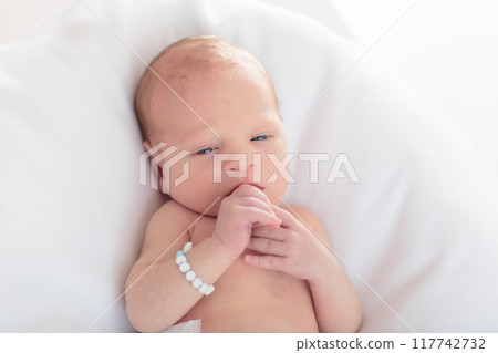 Little baby on white bed 117742732