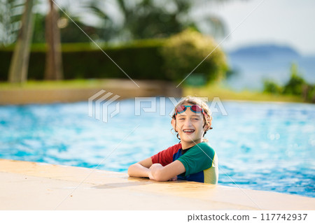Kids jump into swimming pool. Summer water fun. Kids jump into swimming pool. Summer water fun. 117742937