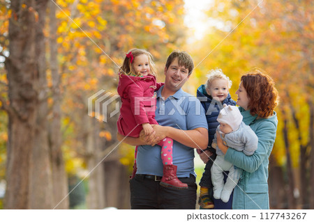 Parents and kids in autumn. Fall outdoor family fun. Parents and kids in autumn. Fall outdoor family fun. 117743267