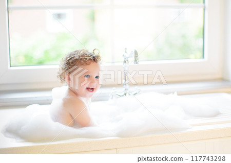 Baby taking bath in kitchen sink 117743298