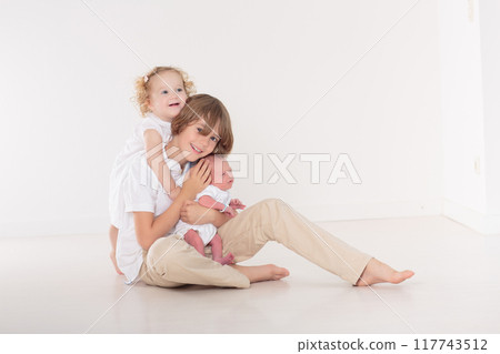 Siblings meet newborn baby Siblings meet newborn baby 117743512