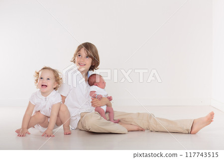 Siblings meet newborn baby 117743515