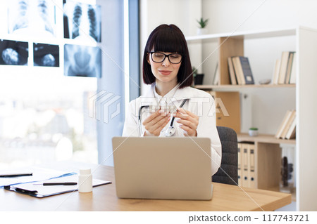 Female doctor working on laptop in medical office Female doctor working on laptop in medical office 117743721
