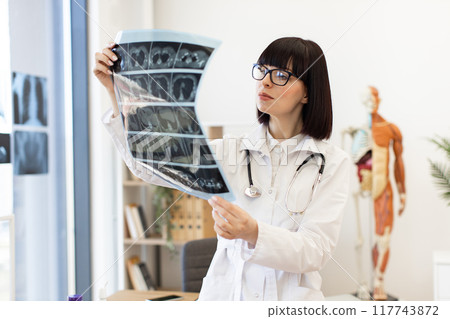 Female doctor examining x-ray in modern medical office Female doctor examining x-ray in modern medical office 117743872