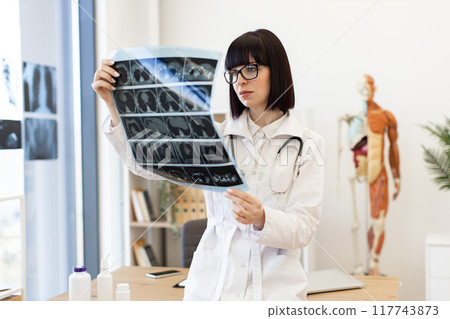 Doctor analyzing x-ray in modern medical office Doctor analyzing x-ray in modern medical office 117743873