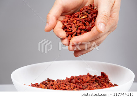 Handful of dried goji berries, gray background 117744115