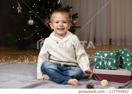 Cheerful little boy near Christmas tree at home 117744807