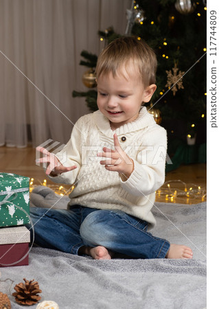 Little two-year-old boy opens Christmas gifts at home Little two-year-old boy opens Christmas gifts at home 117744809