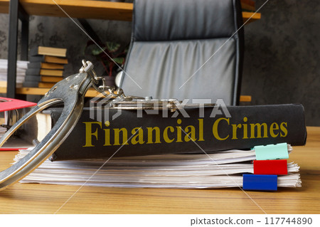Book financial crimes with handcuffs on it. Legal consequences and economic fraud. Book financial crimes with handcuffs on it. Legal consequences and economic fraud. 117744890