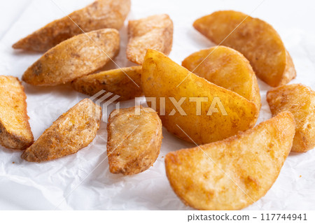 Fried potato wedges isolated on white background. Fried potato wedges isolated on white background. 117744941