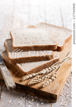 Healthy wholemeal bread slices on rustic wooden table 117744949