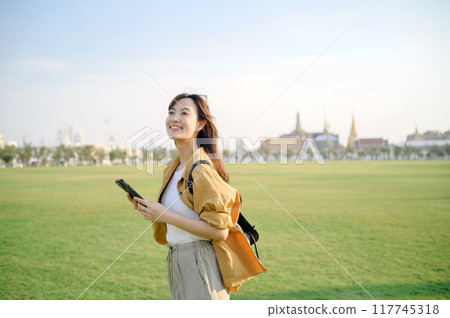 Traveler asian woman in her 30s explores the Grand Palace. Immerse yourself in the history, grandeur, and religious significance of this iconic landmark. Traveler asian woman in her 30s explores the Grand Palace. Immerse yourself in the history, grandeur, and religious significance of this iconic landmark. 117745318