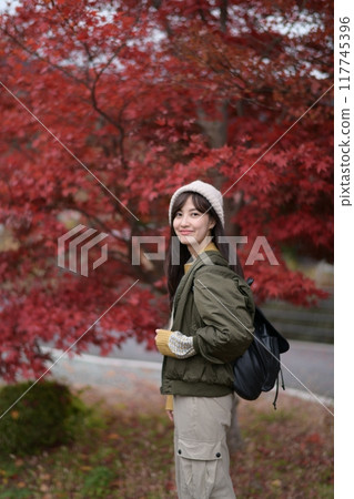 Portrait of a young Asian woman with autumn leaves 117745396