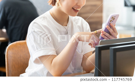 A young Japanese businesswoman using a smartphone with a smile A young Japanese businesswoman using a smartphone with a smile 117745769
