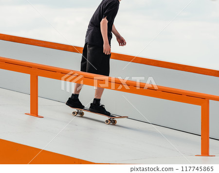 Skateboard Skater Skating in Skate Park Outdoor. Professional skater athlete in black jeans rides a skateboard. Modern sport, subculture and skateboarding concept. Skate as hobby and healthy lifestyle 117745865