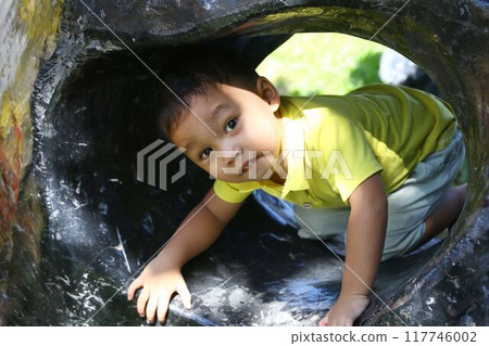 Asian boy about two years old wear a yellow shirt, was playing with a toy. 117746002