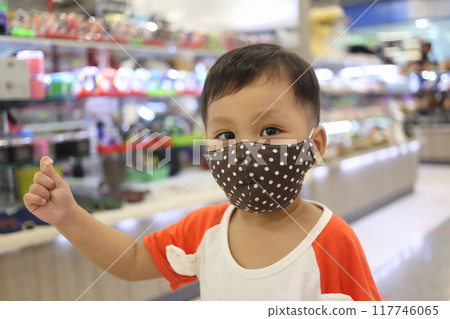 An Asian boy about two years old wears a mask when he goes to a shopping mall. An Asian boy about two years old wears a mask when he goes to a shopping mall. 117746065