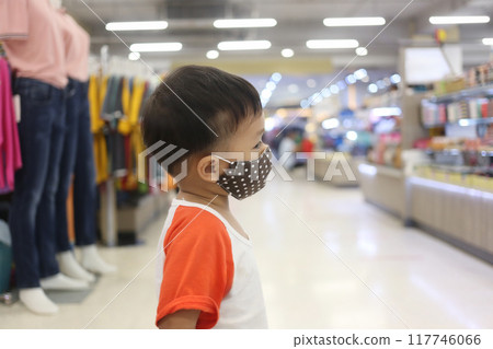 An Asian boy about two years old wears a mask when he goes to a shopping mall. An Asian boy about two years old wears a mask when he goes to a shopping mall. 117746066