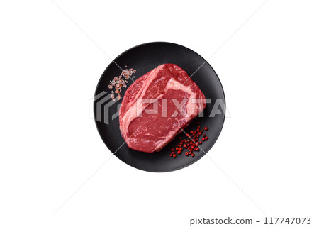 Fresh, raw beef steak with salt, spices and herbs 117747073
