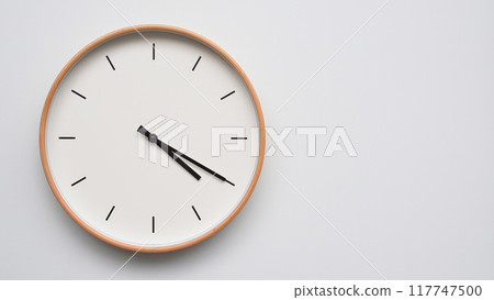 Minimalist wooden Wall Clock on White Wooden Surface with Space for Text. Time Set at 16.20/04.20 117747500
