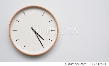 Minimalist wooden Wall Clock on White Wooden Surface with Space for Text. Time Set at 16.25/04.25 117747501