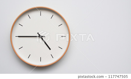 Minimalist wooden Wall Clock on White Wooden Surface with Space for Text. Time Set at 16.45/04.45 117747505