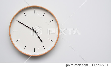 Minimalist wooden Wall Clock on White Wooden Surface with Space for Text. Time Set at 16.50/04.50 Minimalist wooden Wall Clock on White Wooden Surface with Space for Text. Time Set at 16.50/04.50 117747731