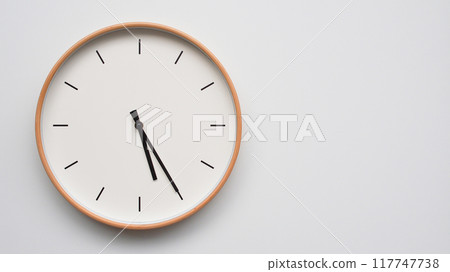 Minimalist wooden Wall Clock on White Wooden Surface with Space for Text. Time Set at 17.25/05.25 Minimalist wooden Wall Clock on White Wooden Surface with Space for Text. Time Set at 17.25/05.25 117747738