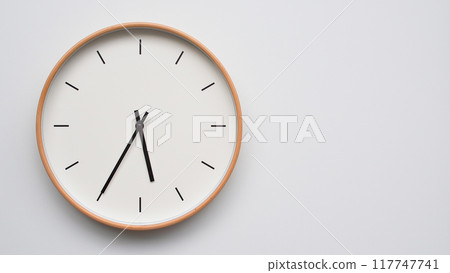 Minimalist wooden Wall Clock on White Wooden Surface with Space for Text. Time Set at 17.35/05.35 Minimalist wooden Wall Clock on White Wooden Surface with Space for Text. Time Set at 17.35/05.35 117747741