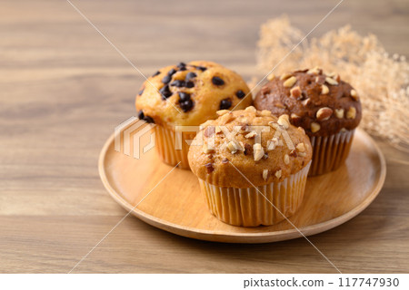 Vanilla almond muffin, Chocolate almond muffin and Vanilla chocolate chips muffin on wooden plate 117747930
