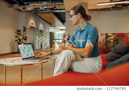 A Business Professional is Working Remotely in a Modern Office Space with Great Vibes A Business Professional is Working Remotely in a Modern Office Space with Great Vibes 117748793