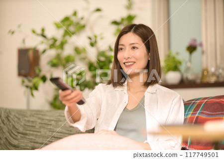 中年婦女在沙發上放鬆地看電視 117749501