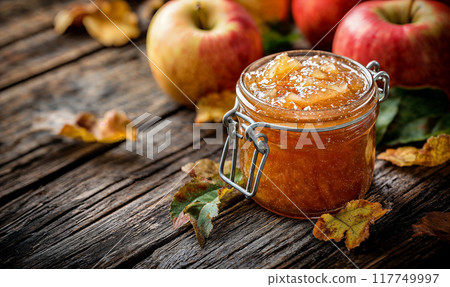 Apple jam in glass jar, rustic wooden background with copy space, AI generated 117749997
