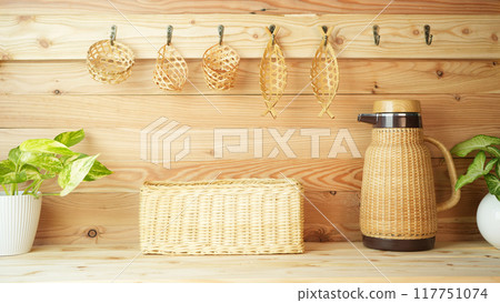 bamboo and wooden woven basket hanging on wooden wall with basket on wooden counter 117751074