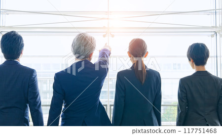 A group of business people of all ages walking through the lobby 117751468