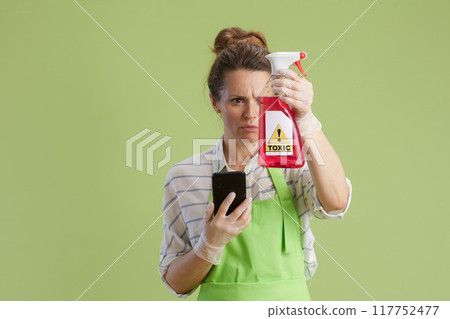 concerned woman using smartphone against green 117752477