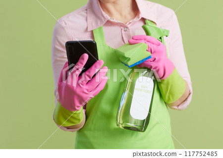 Modern female using smartphone against green Modern female using smartphone against green 117752485