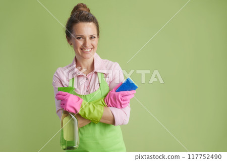 smiling woman in green apron and rubber gloves against green 117752490